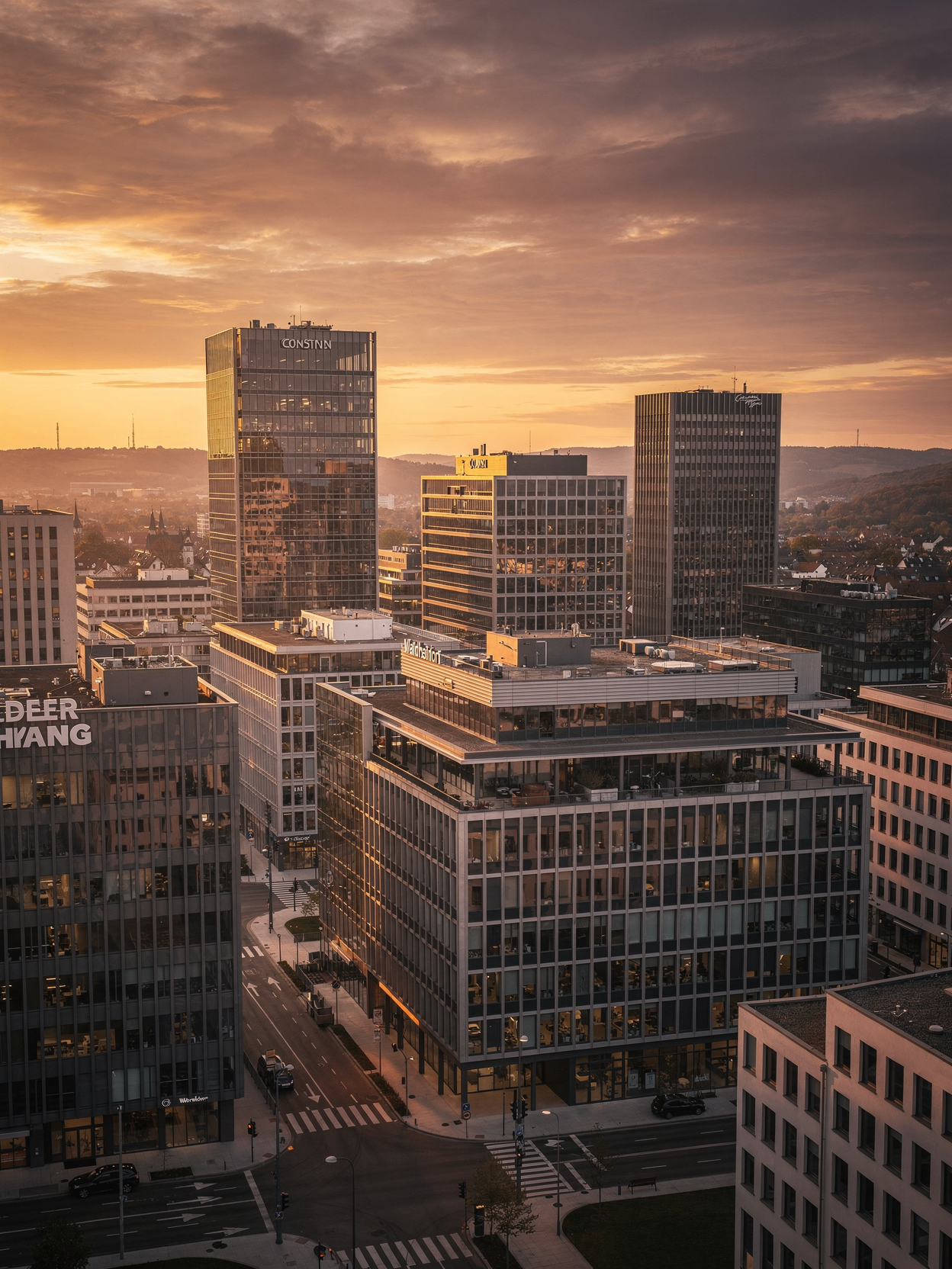 Aerial view of a modern glass office building at sunset